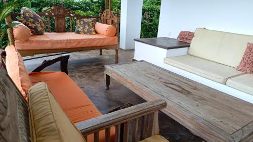 a patio with couches and a table and chairs at Shalom Wellspring Homestay in Malindi
