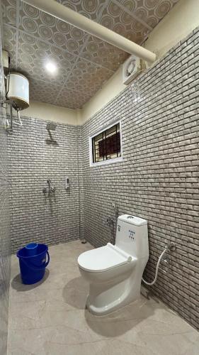 a bathroom with a white toilet in a room at The Gulmohar Inn in Guwahati