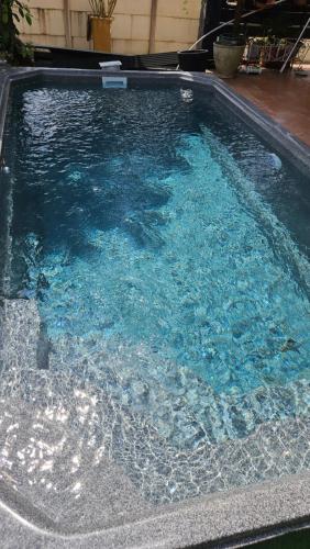 une grande piscine d'eau bleue dans une cour dans l'établissement Villa Zaphira, à Gujan-Mestras