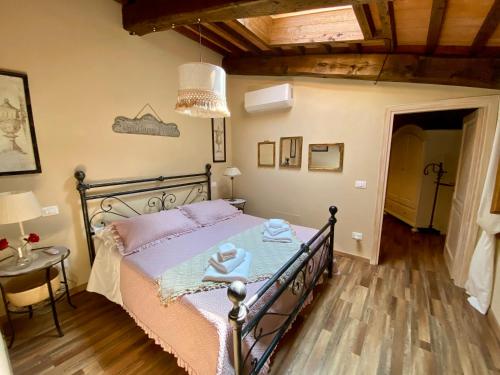 a bedroom with a bed with pink sheets and a chandelier at La Romantica in Chianni