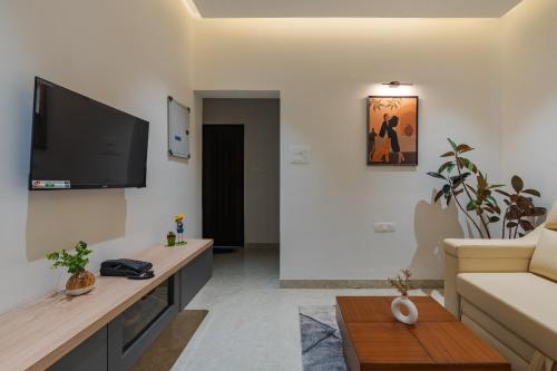 a living room with a couch and a flat screen tv at Everest Serenity Service Apartments in Coimbatore