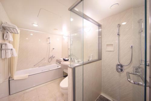 a bathroom with a shower and a toilet and a sink at Hotel Nikko Nara in Nara