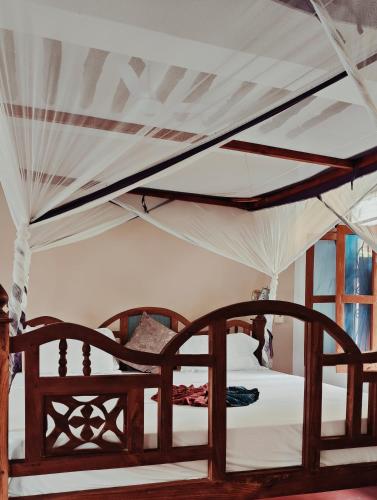 a bedroom with two beds with white sheets at Laguna Palace Resort in Michamvi