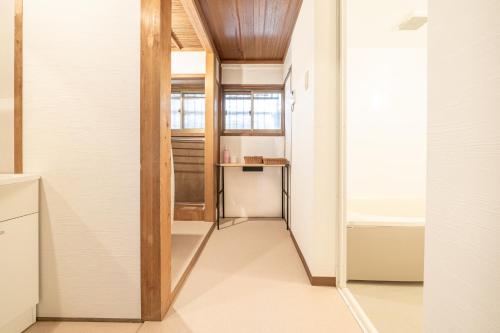 a room with a hallway with a table and a window at Sanada Maru in Kaizuka