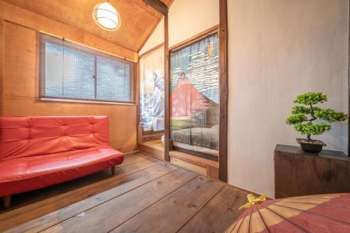 a living room with a red couch and a window at Sanada Maru in Kaizuka