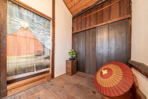 a room with a large window and a red umbrella at Sanada Maru in Kaizuka