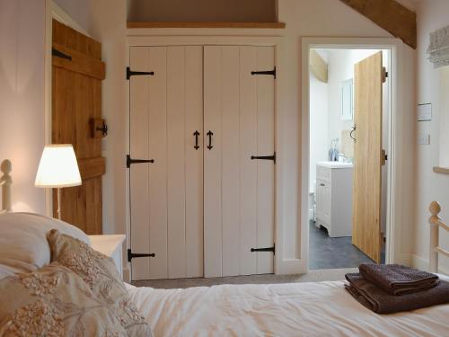 a bedroom with a bed and a bathroom at The Granary in Tiverton