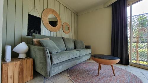 un salon avec un canapé vert et une table dans l'établissement Studio les pieds dans l'eau, à Duingt