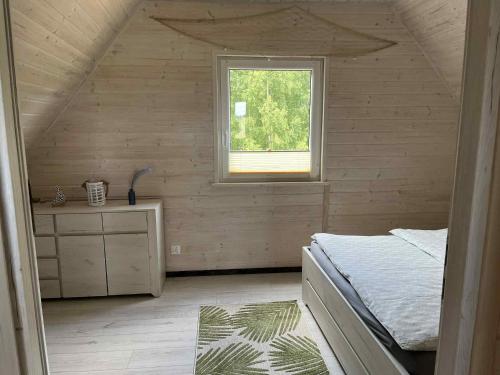 a bedroom with a bed and a window at "Morze Spokoju" domki letniskowe in Darlowko