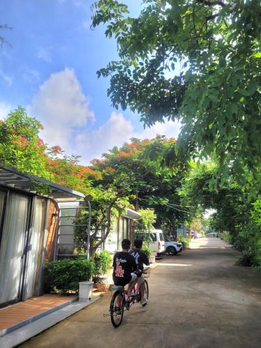 two people riding a bike down a street at An Hoa Residence in Long Hai