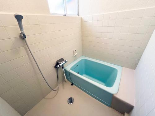 Un baño con una bañera azul en la esquina. en 赤磐ベース, en Akaiwa