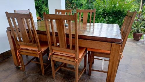 a wooden table with four wooden chairs around it at Shalom Wellspring Homestay in Malindi