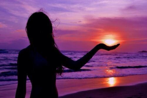 a woman standing on the beach looking at the sunset at Hotel Beachfront Vista Hermosa in Jacó