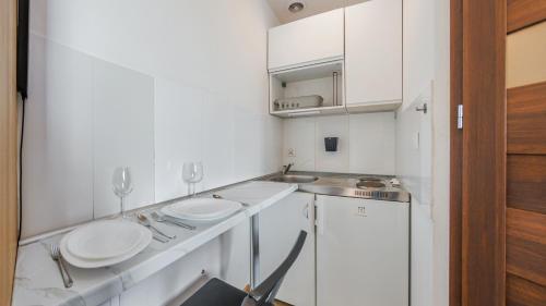a small white kitchen with two sinks and a dishwasher at Obrońców Wybrzeża, Sun & Snow in Puck