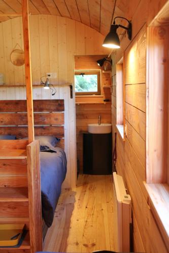 a small bedroom with a bed and a sink at Ferme de Pitoué in Campbon