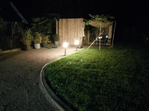 a yard at night with a light in the grass at Le Lodge de la Hutt' aux animaux 