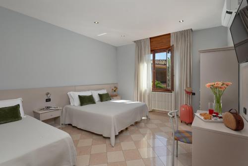 a hotel room with two beds and a window at Il Torchio di Alchieri Moreno e C SAS in Pizzighettone