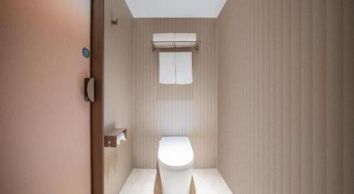 un bagno con un water bianco in una cabina di Hanting Hotel Zhangjiajie Tianmen Mountain Zhongshang Plaza a Zhangjiajie