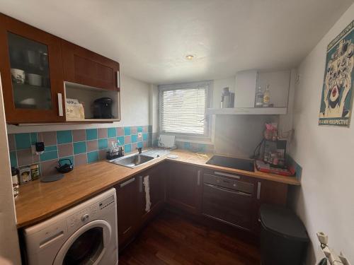 une petite cuisine avec un évier et une machine à laver dans l'établissement Chambre double et petit déjeuner chez l habitant, à Ivry-sur-Seine