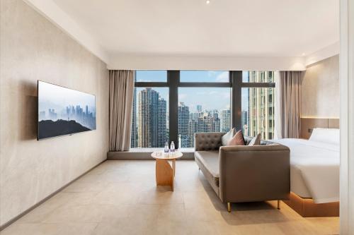 a hotel room with a bed and a couch at Xiyada Hotel（Chongqing Guanyinqiao） in Chongqing