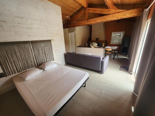 a bedroom with a bed and a couch in a room at Bienvenue chez nous ! in Combrand