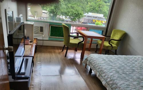 a room with a bed and a table and chairs at 오색약수온천모텔 Osaek Hot Spring Motel in Yangyang