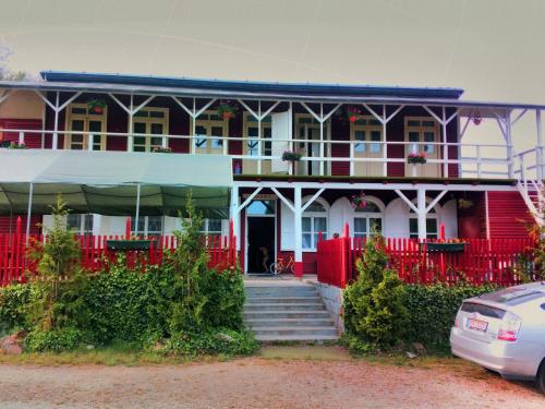 a red and white house with a red fence at Kempink U Šerifa in Protivín