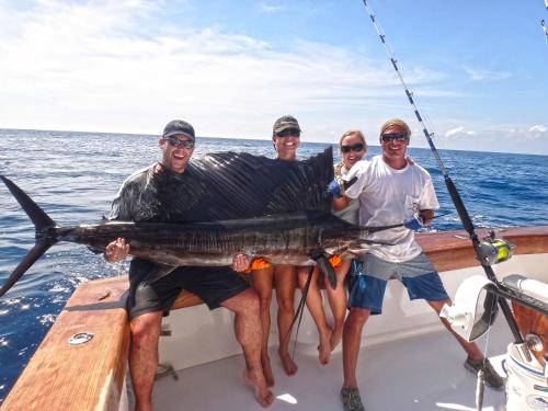 a group of people holding a large fish on a boat at HRG Condos at Los Sueños in Jacó