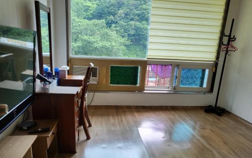 a room with a desk and a large window at 오색약수온천모텔 Osaek Hot Spring Motel in Yangyang