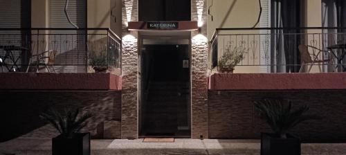 a building with a black door with a sign on it at Katerina Apartments in Kalamata