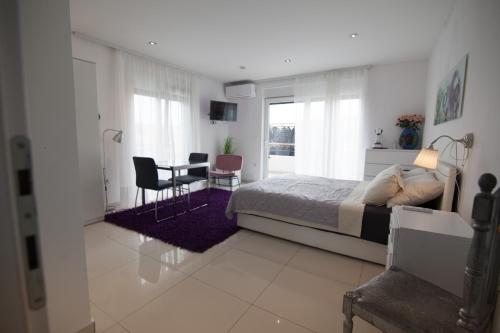 Un dormitorio con una cama y una mesa y sillas. en Basic Mansion Mandalina, en Šibenik