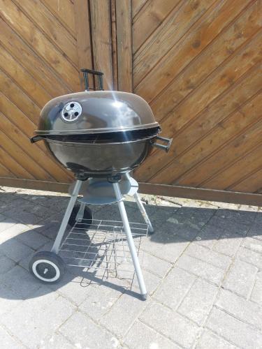 a grill sitting on a stand in front of a fence at Apartment Nähe Limburg Diez in Heistenbach