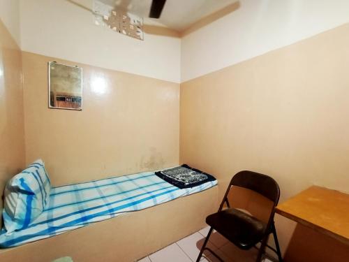 a room with a bed and a chair in it at VRP Guest House in Bhuj