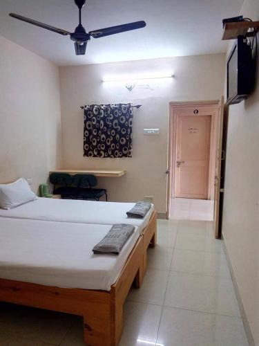 a bedroom with a bed and a ceiling fan at VRP Guest House in Bhuj