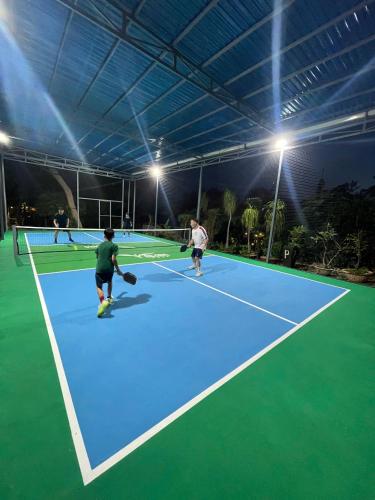 a group of people playing tennis on a tennis court at An Hoa Residence in Long Hai