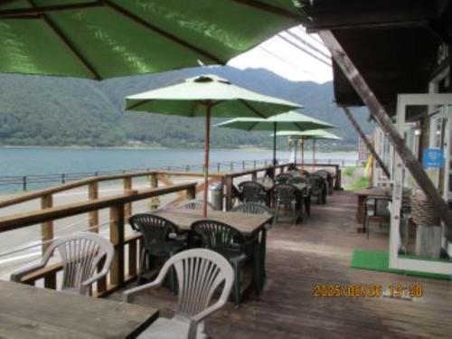 a row of tables and chairs with umbrellas on a deck at Sun Lake in Fujikawaguchiko