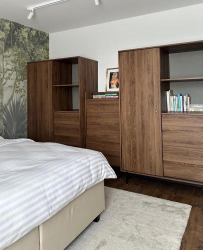 a bedroom with wooden cabinets and a bed at Apartmány Panoráma Bojnice in Bojnice
