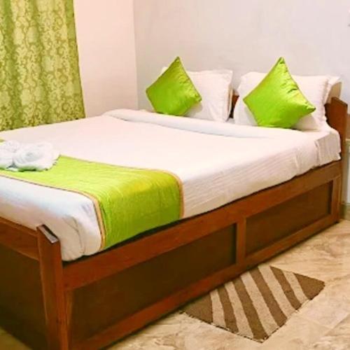 a bed with green and white pillows on it at DELI-BAIAR guest house in Mawlynnong