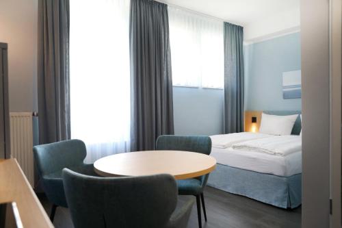 una camera d'albergo con letto, tavolo e sedie di Michels Haus Wilhelm-Augusta a Norderney