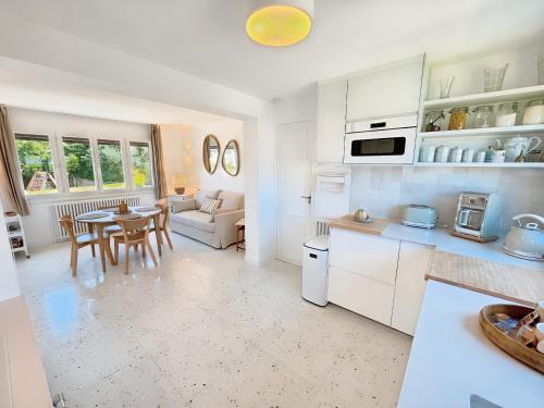 une cuisine et un salon avec une table et des chaises dans l'établissement La Maison de Ranville - Entre Caen & la Mer avec jardin et parking gratuit, à Ranville