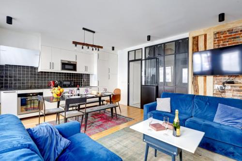 un salon avec un canapé bleu et une cuisine dans l'établissement 245 Suite Mercedes - Superb apartment in Paris, à Paris