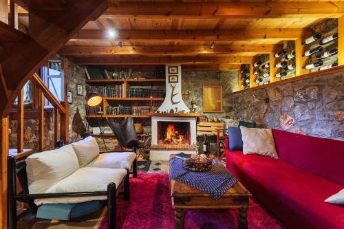a living room with a red couch and a fireplace at Pine Forest Chalet 1400m, Cinema & Fireplace in Artemisía