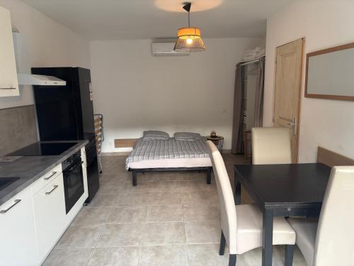 a kitchen with a table and a bed in a room at Studio tout équipé à la nuitée ou plus,proche aéroport Bastia in Lucciana