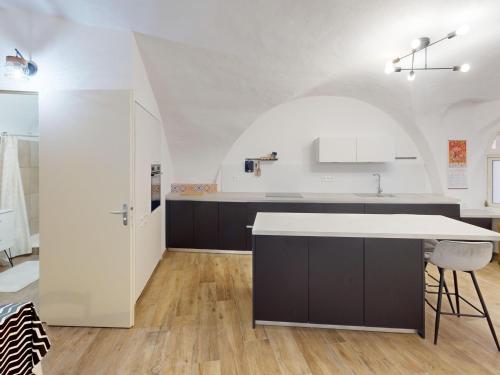 une cuisine avec un comptoir blanc et un îlot de cuisine dans l'établissement Maison de maître à Poussan - 6 pers, spa et charme ancien - FR-1-785-21, à Poussan