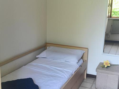 a small bedroom with a bed with white sheets and a window at Grazioso bilocale in Giusvalla