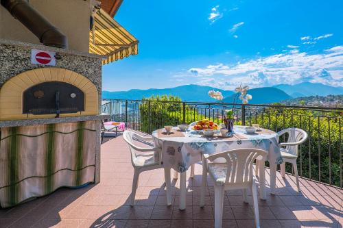a table and chairs on a balcony with a stove at Casetta di Rosetta in Arizzano