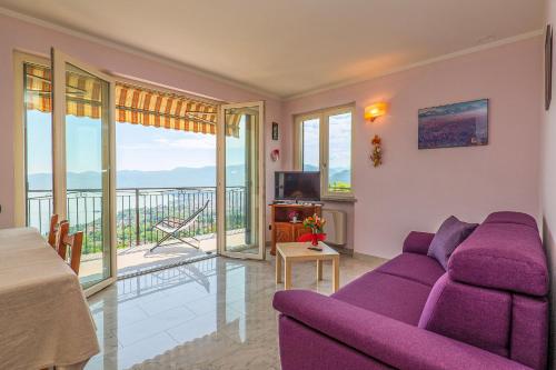 a living room with a purple couch and a balcony at Casetta di Rosetta in Arizzano