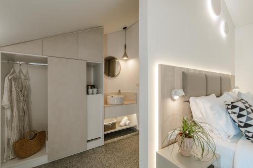 a white bedroom with a bed and a closet at Hotel Rezi in Parga