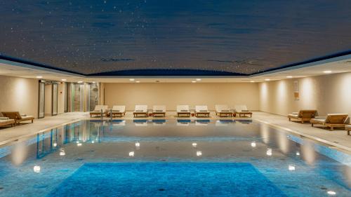a pool in a hotel with chairs and tables at Siu Collection - Ultra All Inclusive in Beldibi