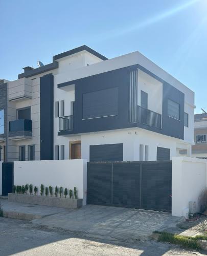 a large white house with a black garage at Luxury house in Martil in Martil